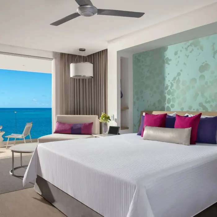 Oceanfront junior suite featuring a king bed and balcony seating.