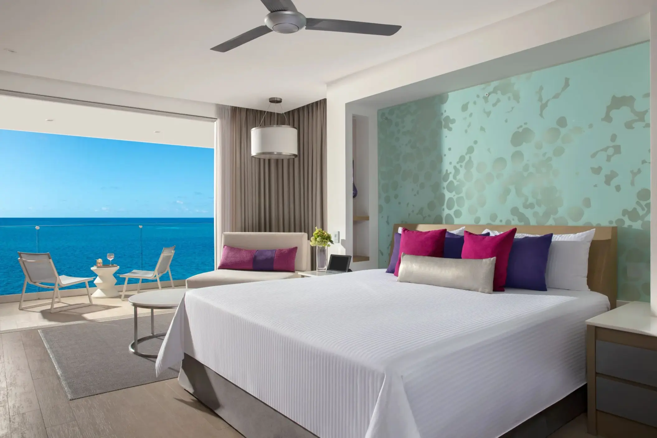 Oceanfront junior suite featuring a king bed and balcony seating.
