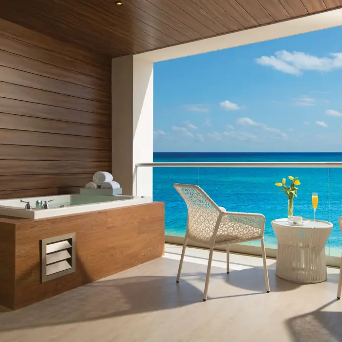 Outdoor terrace with hot tub, sea view, and cozy seating at Breathless Riviera Cancun.