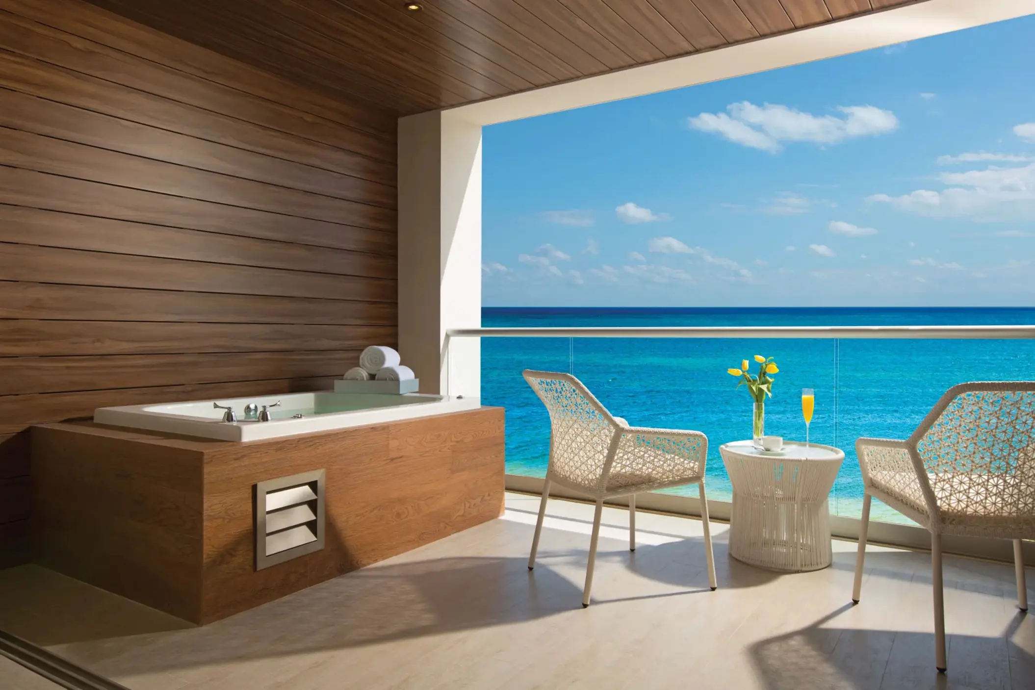 Outdoor terrace with hot tub, sea view, and cozy seating at Breathless Riviera Cancun.