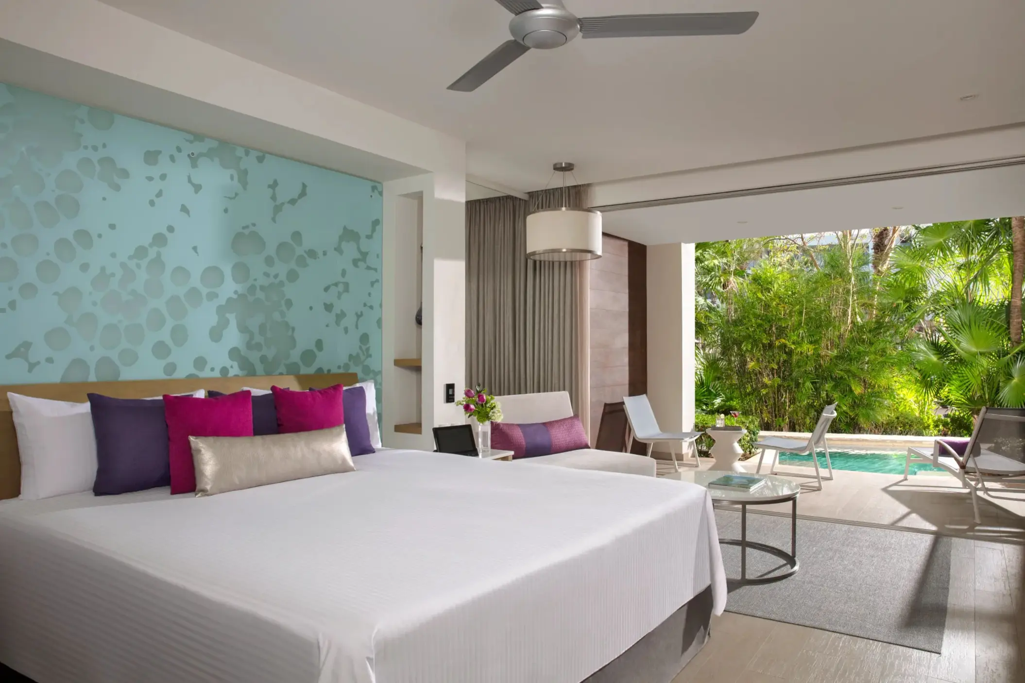 Junior suite with king bed, tropical view, and furnished terrace surrounded by lush greenery and privacy.