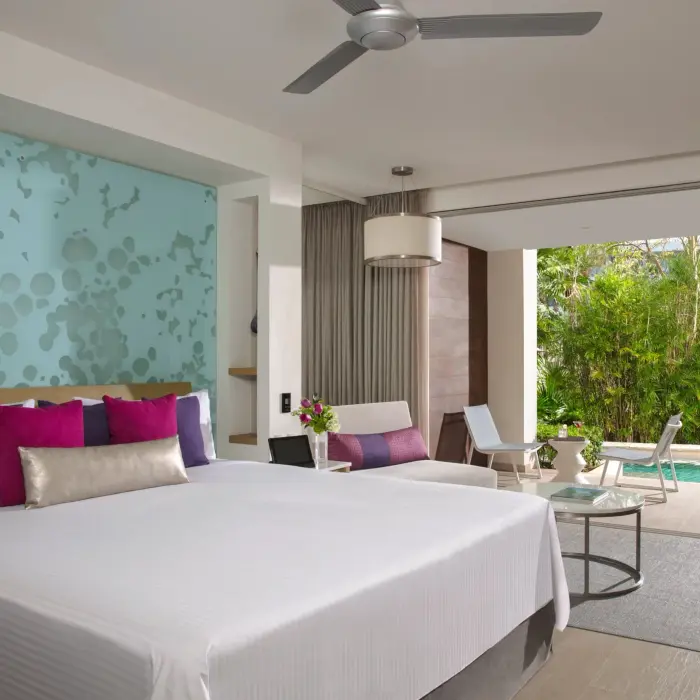 Junior suite with king bed, tropical view, and furnished terrace surrounded by lush greenery and privacy.
