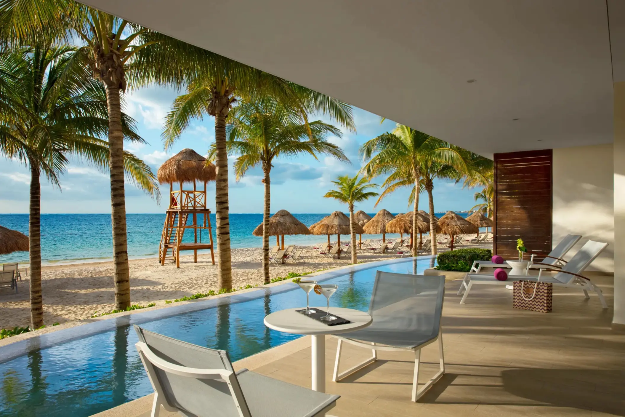 Oceanfront master suite with spacious terrace, sun loungers, and direct beach access just steps away.