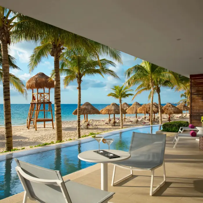 Oceanfront master suite with spacious terrace, sun loungers, and direct beach access just steps away.