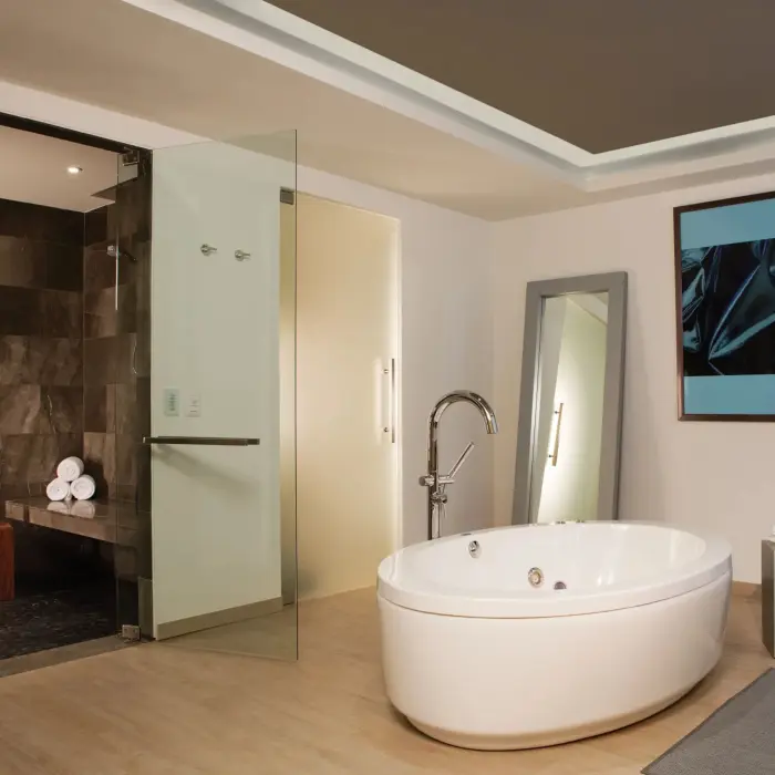 Presidential suite bathroom with modern oval soaking tub, glass-enclosed shower, and sleek finishes.