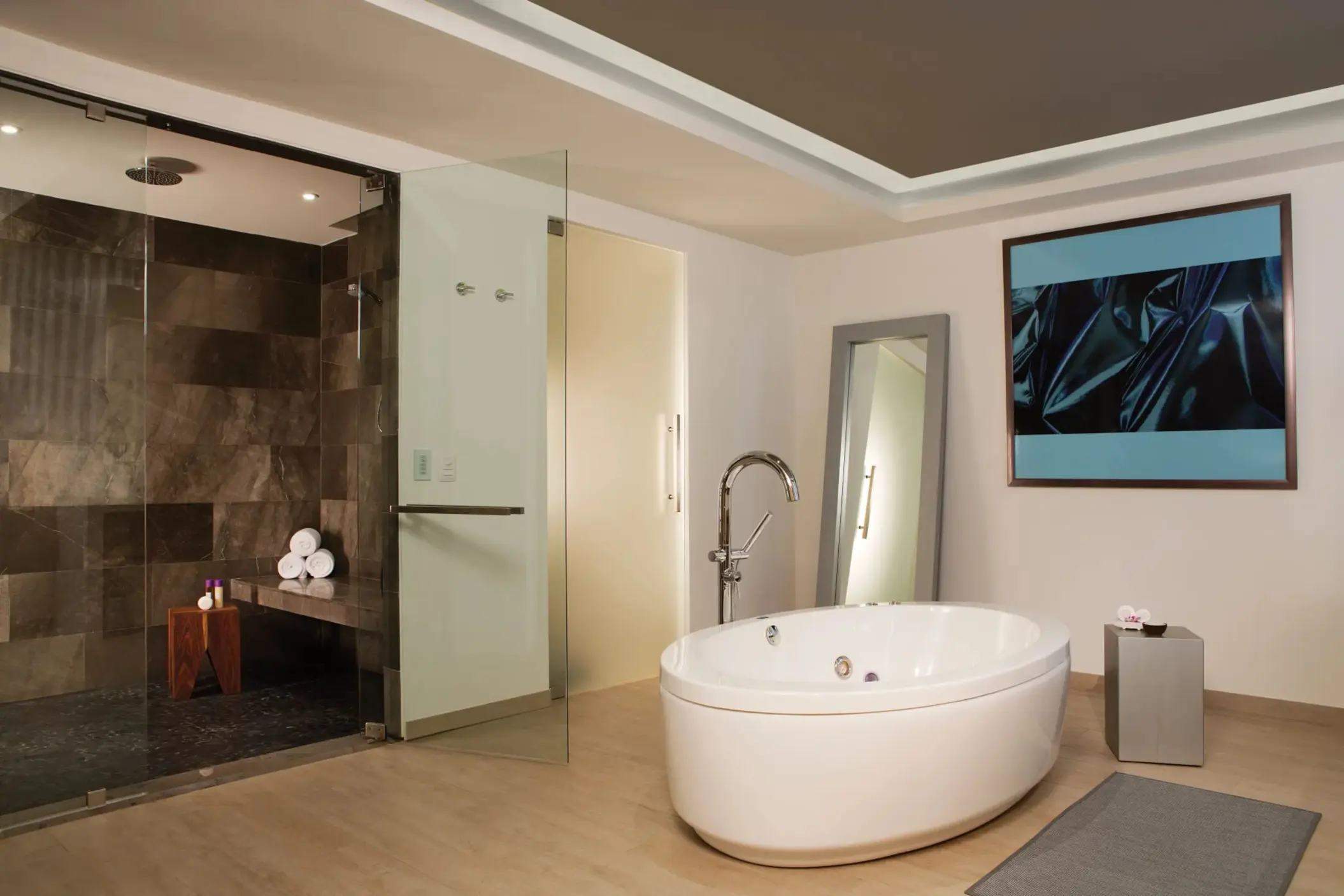 Presidential suite bathroom with modern oval soaking tub, glass-enclosed shower, and sleek finishes.