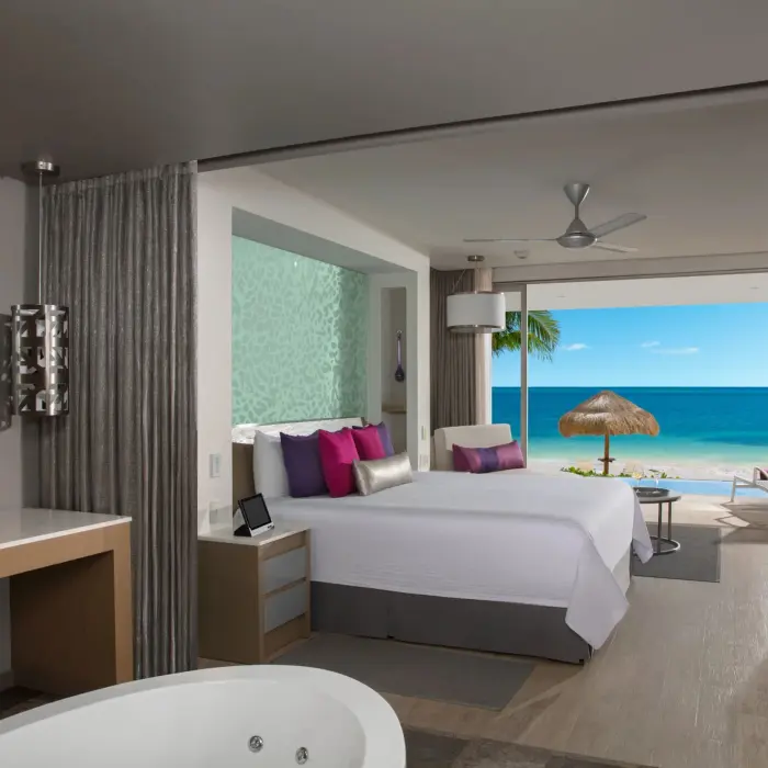 Oceanfront master suite with a king bed, soaking tub, and private terrace overlooking the Caribbean Sea.