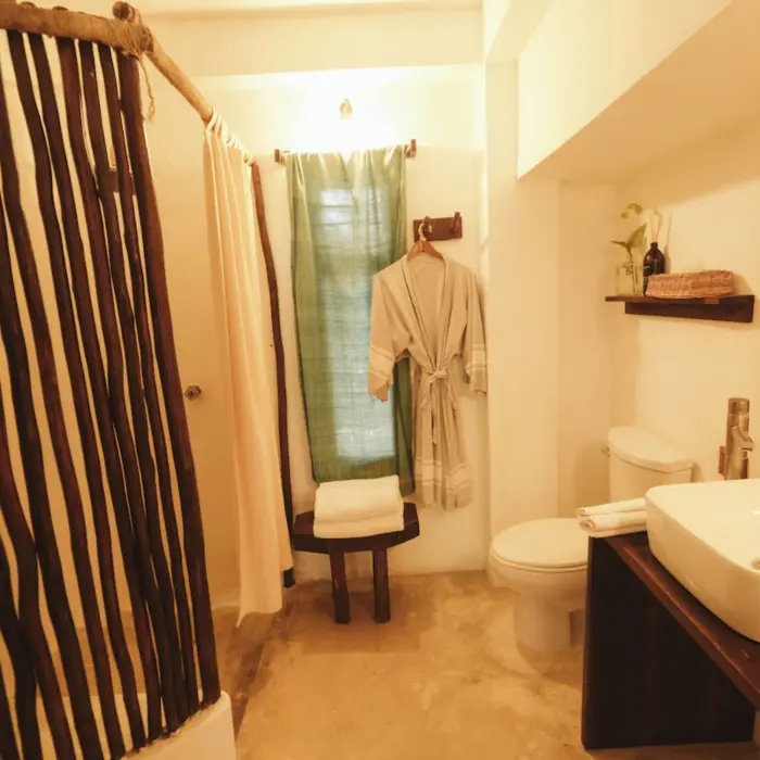 washroom of romantic room with bathrobe hanging on the wall at Casa Violeta