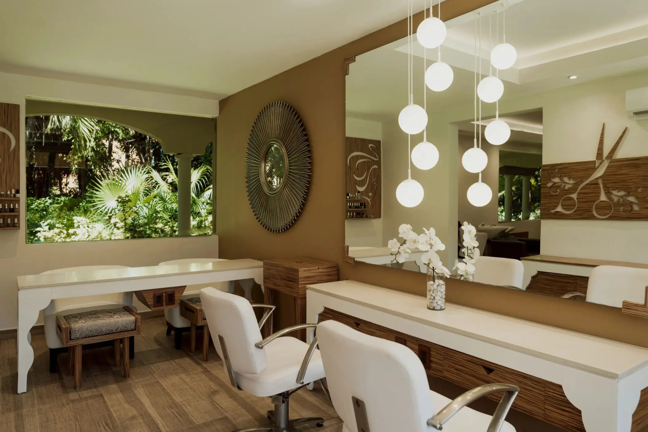 chic and modern salon at Catalonia Playa Maroma with white styling chairs, large mirrors, and decorative lighting.