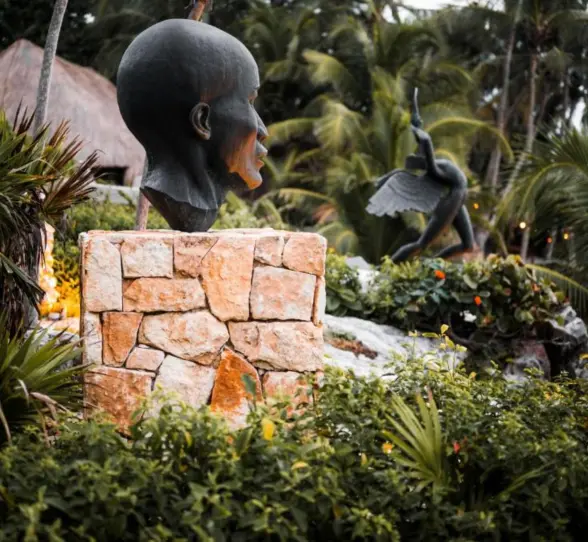 Large, unique art sculptures placed amidst lush tropical plants at the resort.