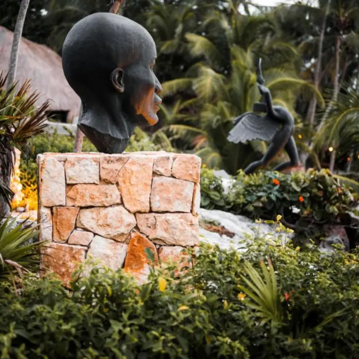 Large, unique art sculptures placed amidst lush tropical plants at the resort.