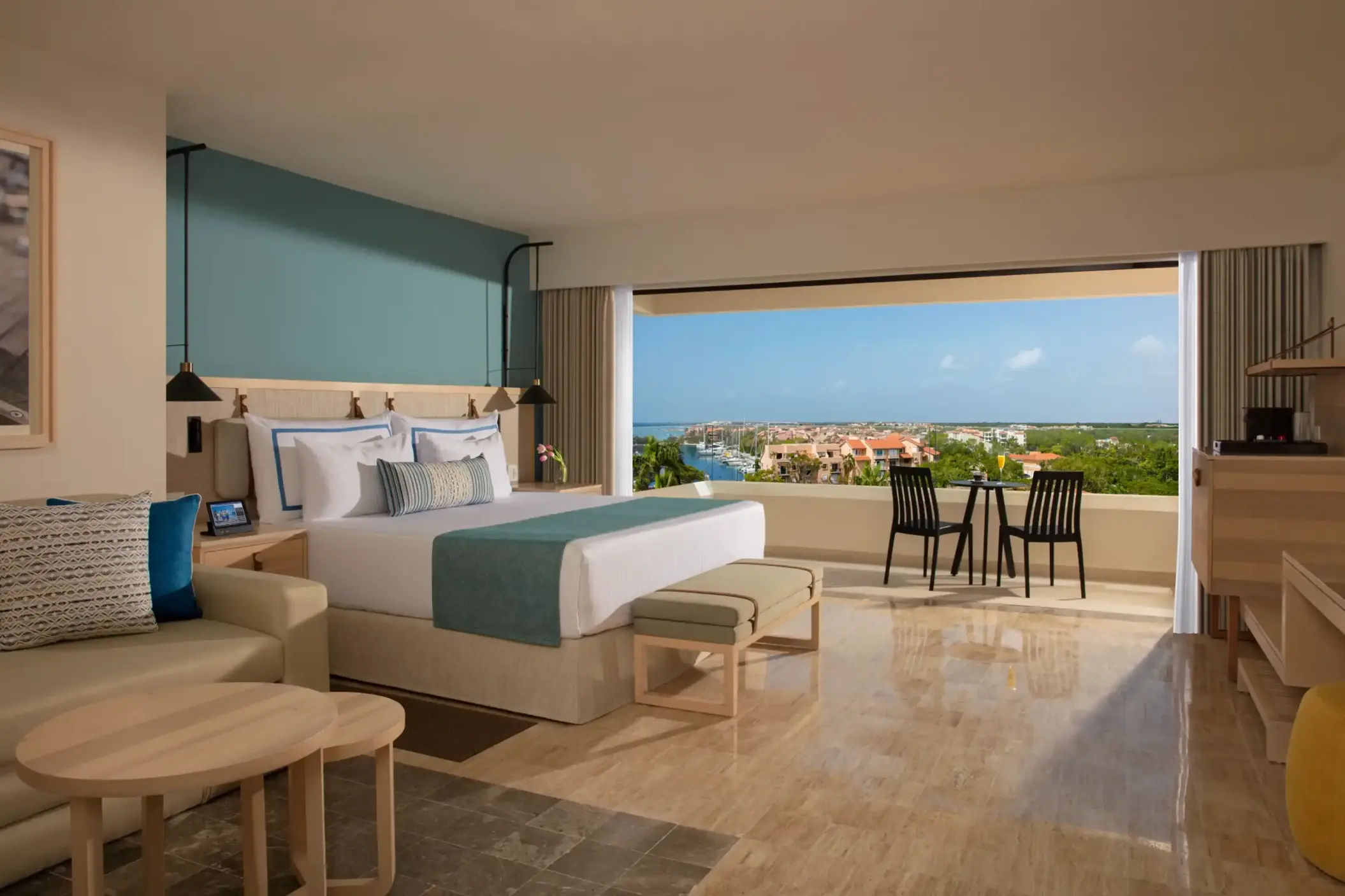 Stylish deluxe room with large windows framing the marina and contemporary coastal decor.
