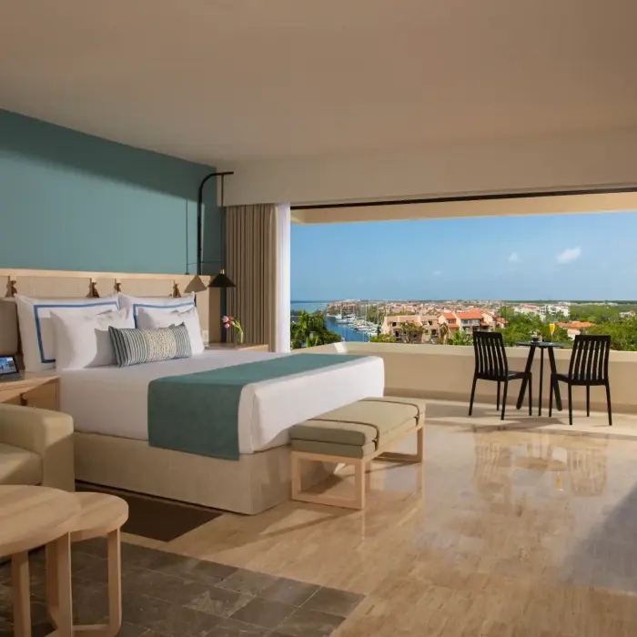 Stylish deluxe room with large windows framing the marina and contemporary coastal decor.