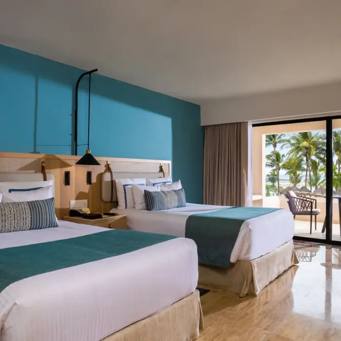 Double deluxe room with vibrant pool view, accented with airy interiors and tropical charm.