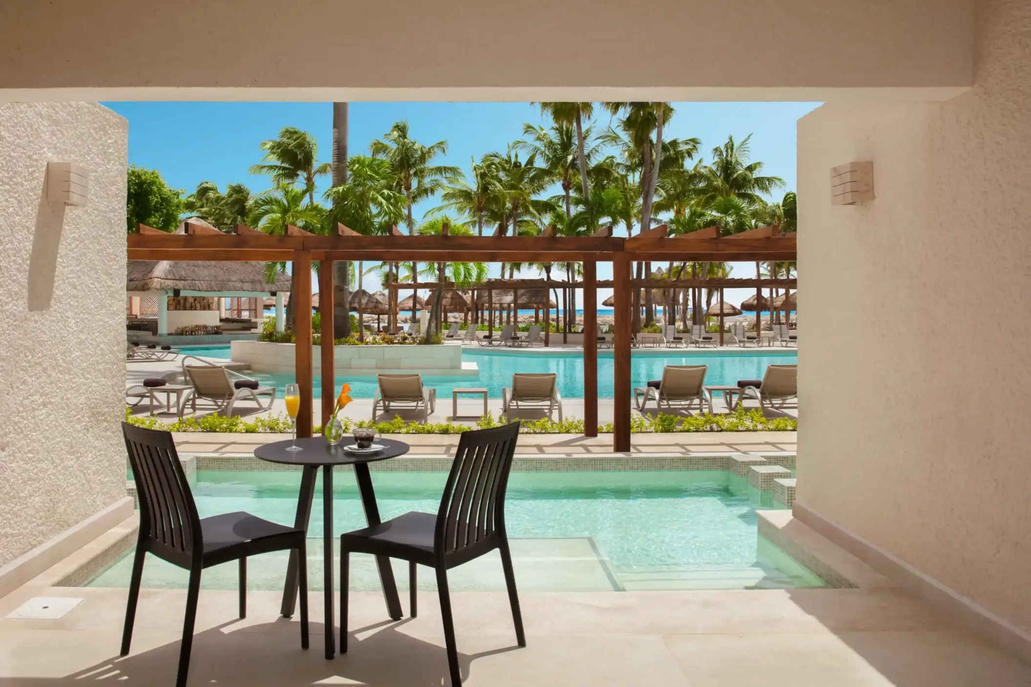 Pool-view deluxe room with sofa and terrace, ideal for relaxing in tropical style.