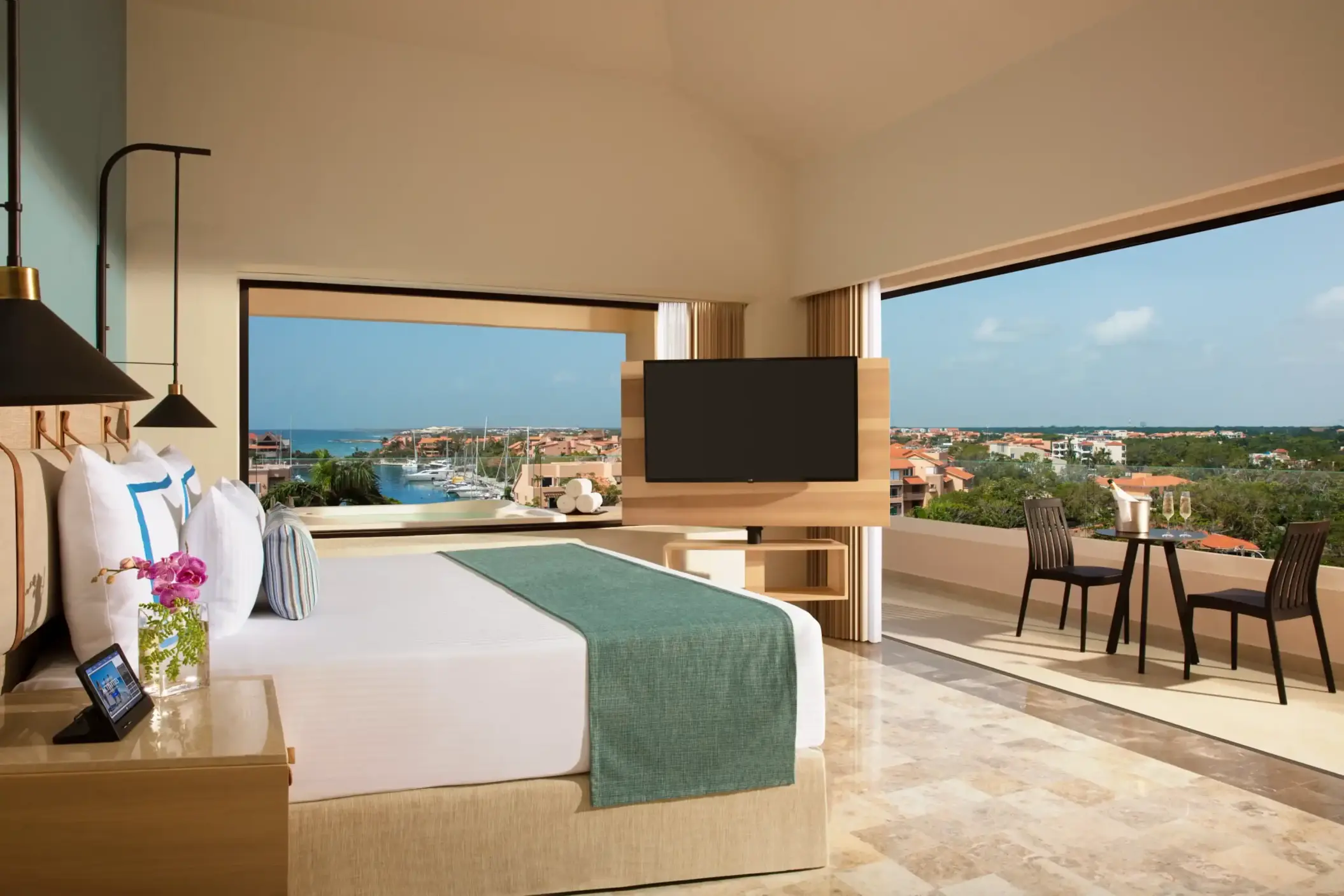 Cozy marina view room with elegant wood accents and a sunlit private balcony at Dreams Puerto Aventuras.