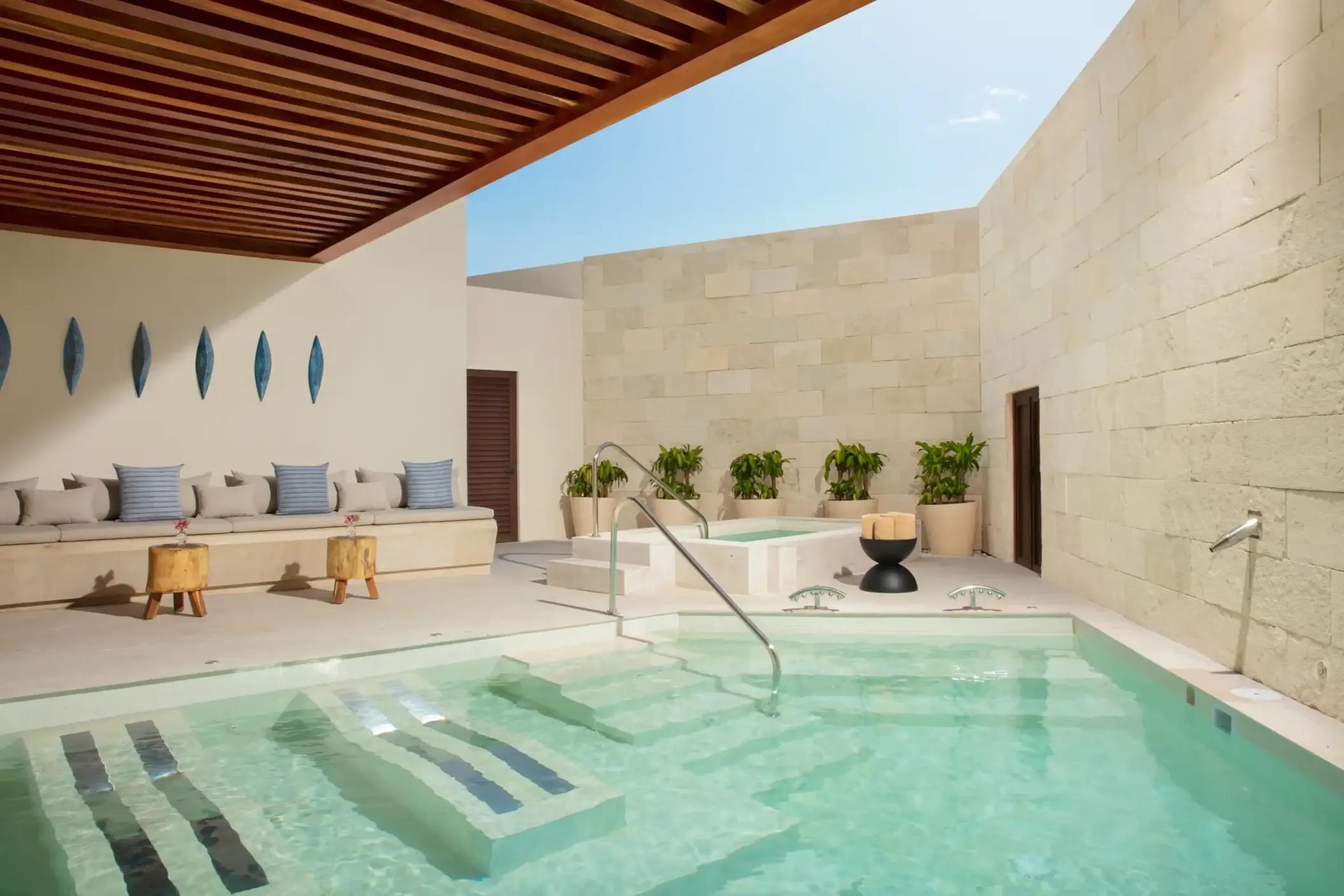 Private hydrotherapy area with plunge pool, warm lighting, modern seating, and serene spa-like atmosphere.
