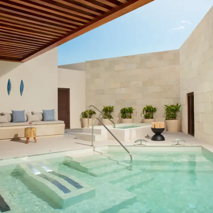 Private hydrotherapy area with plunge pool, warm lighting, modern seating, and serene spa-like atmosphere.