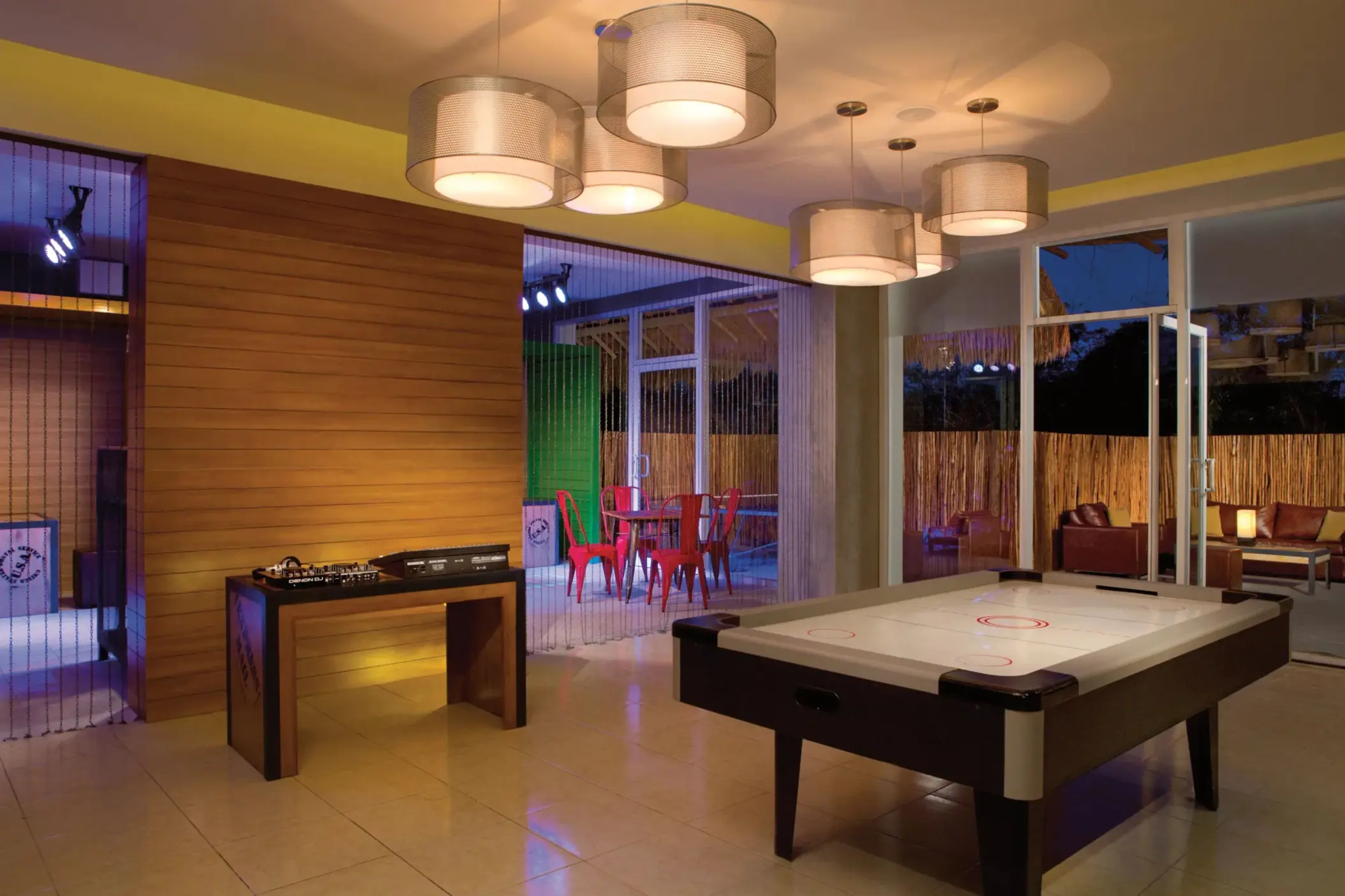 Core Zone teen lounge with DJ table, air hockey, colorful seating, and relaxed indoor vibe.
