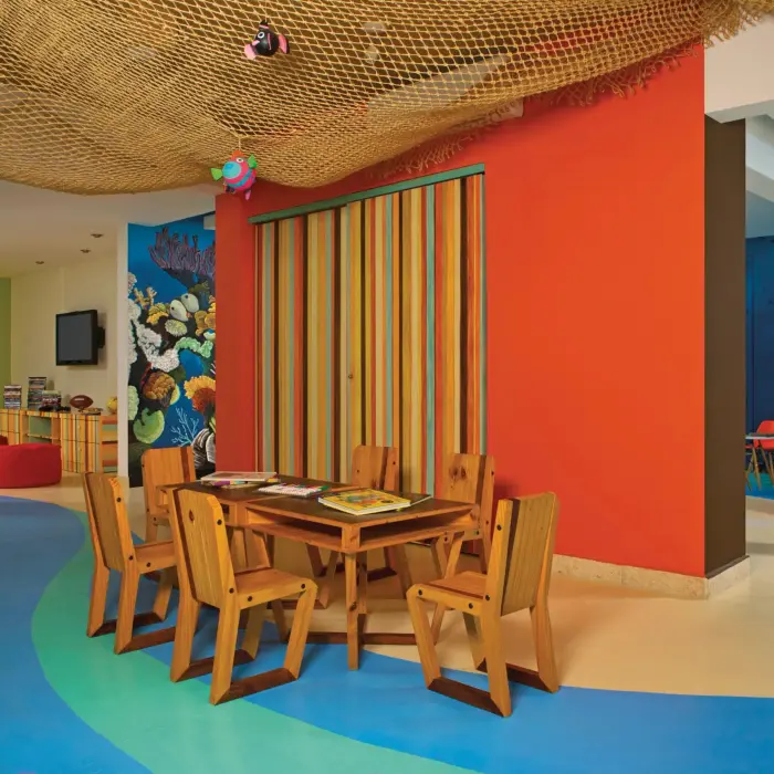 Explorer’s Club playroom with hand-painted murals, kids' table, bean bags, and bright ocean-themed decor.