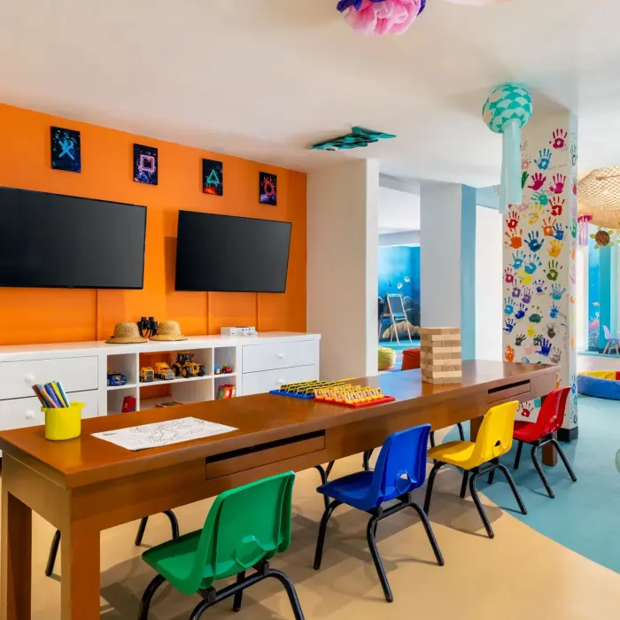 Colorful Explorer’s Club room with games, TV screens, mini chairs, and playful jellyfish decorations.