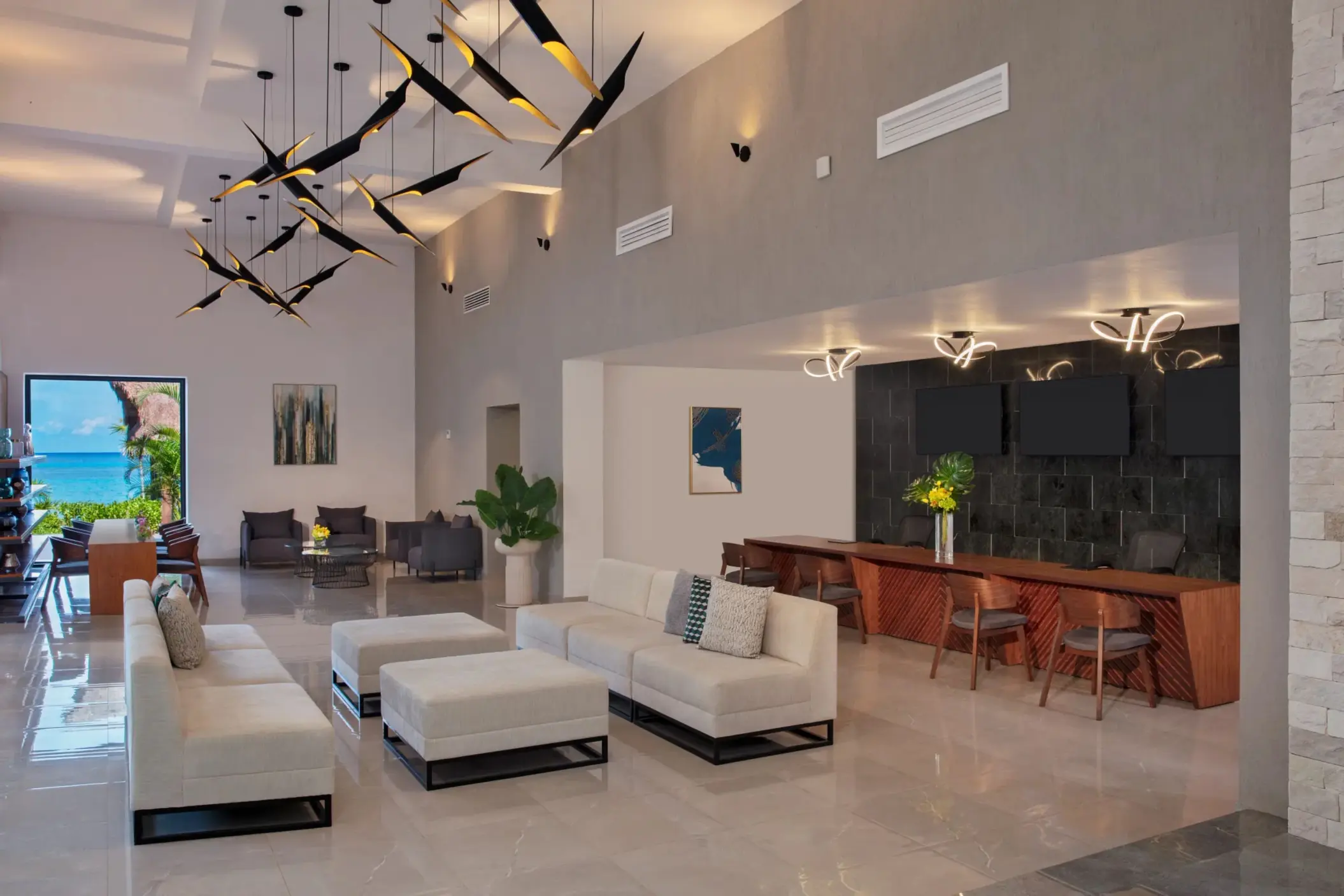 Contemporary resort lobby with chic lounge seating, artful lighting, and views of the ocean beyond.
