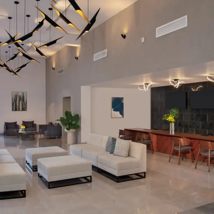 Contemporary resort lobby with chic lounge seating, artful lighting, and views of the ocean beyond.