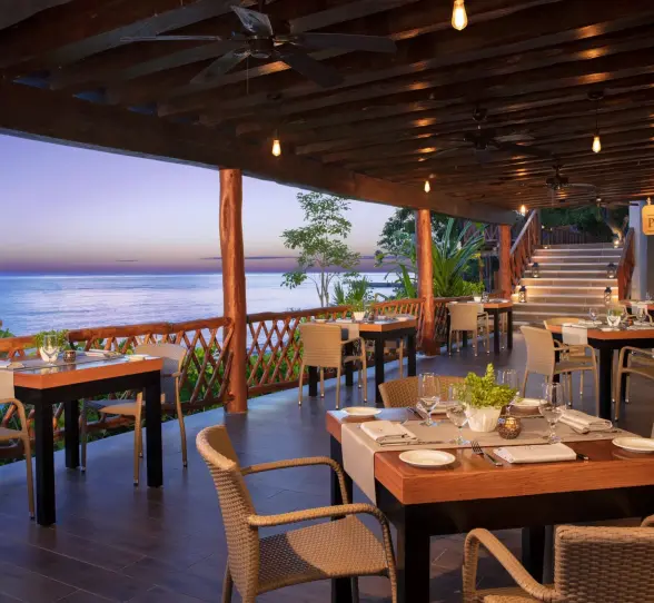 Cozy outdoor seating at the resort’s ocean-view pizzeria, perfect for evening dining with rustic charm.