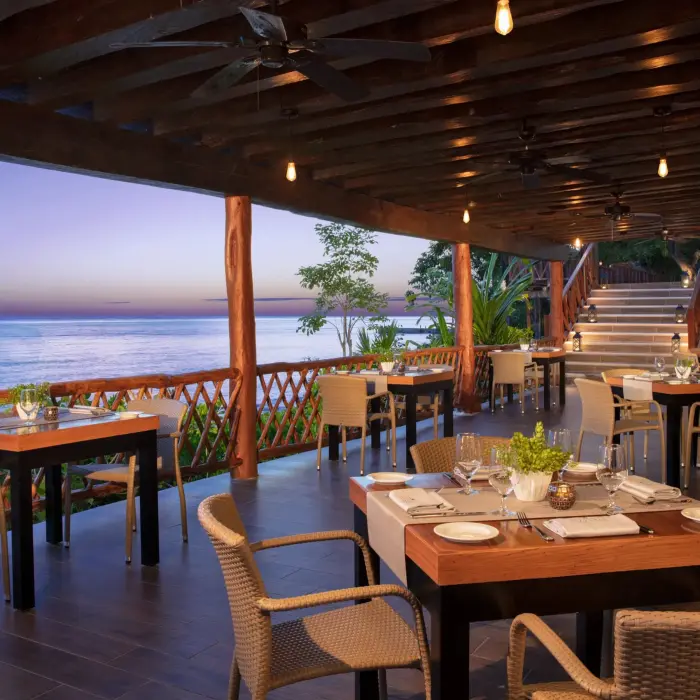 Cozy outdoor seating at the resort’s ocean-view pizzeria, perfect for evening dining with rustic charm.