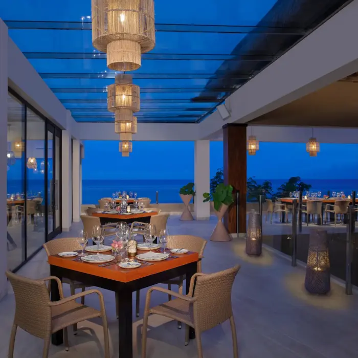 Elegant outdoor terrace at Olio featuring sunset views and lantern lighting for a romantic dinner.