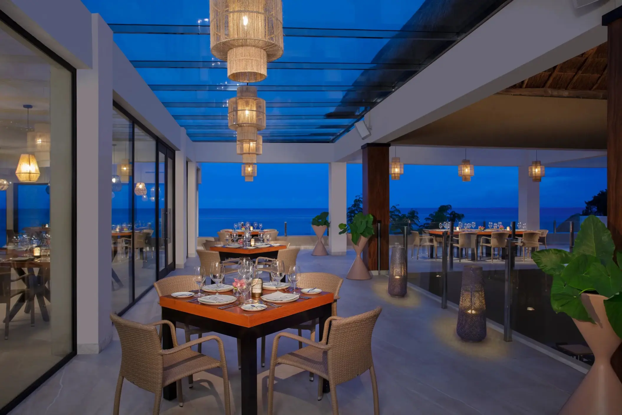 Elegant outdoor terrace at Olio featuring sunset views and lantern lighting for a romantic dinner.