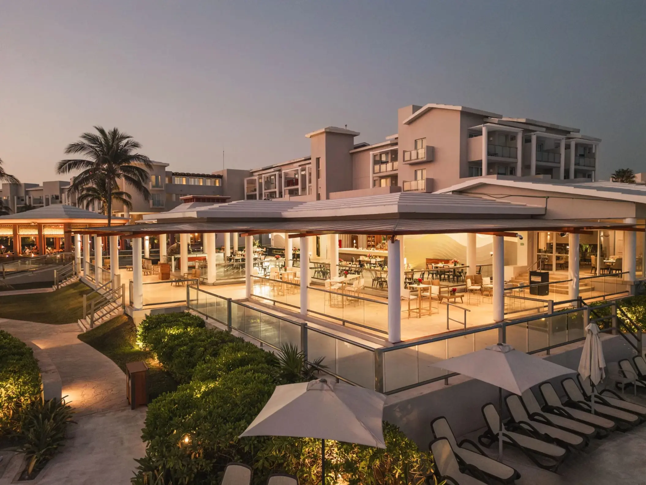Evening view of open-air restaurant at Dreams Jade Resort, surrounded by lush landscaping and soft lighting.