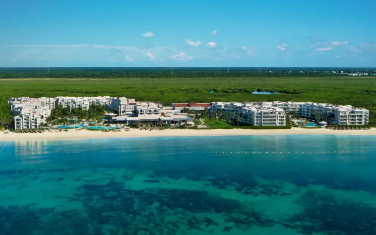 Aerial view of Dreams Jade Resort & Spa with beachfront location and lush greenery in the background.