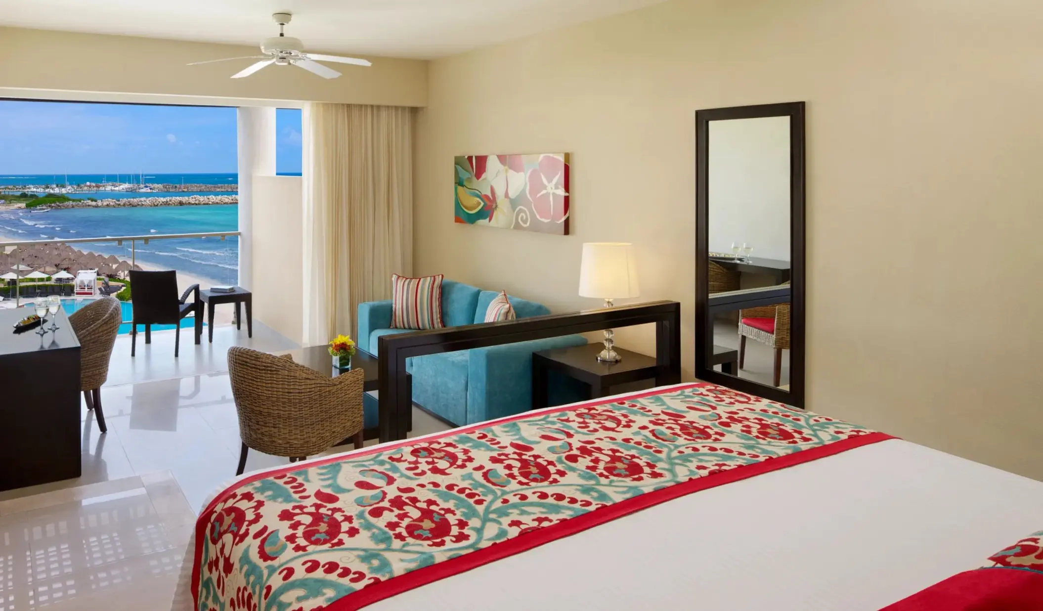 King suite with panoramic ocean view, private balcony, work desk, and cozy sitting area.