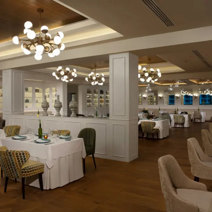 Bright, modern restaurant with white tablecloths, stylish lighting fixtures, and contemporary decor.