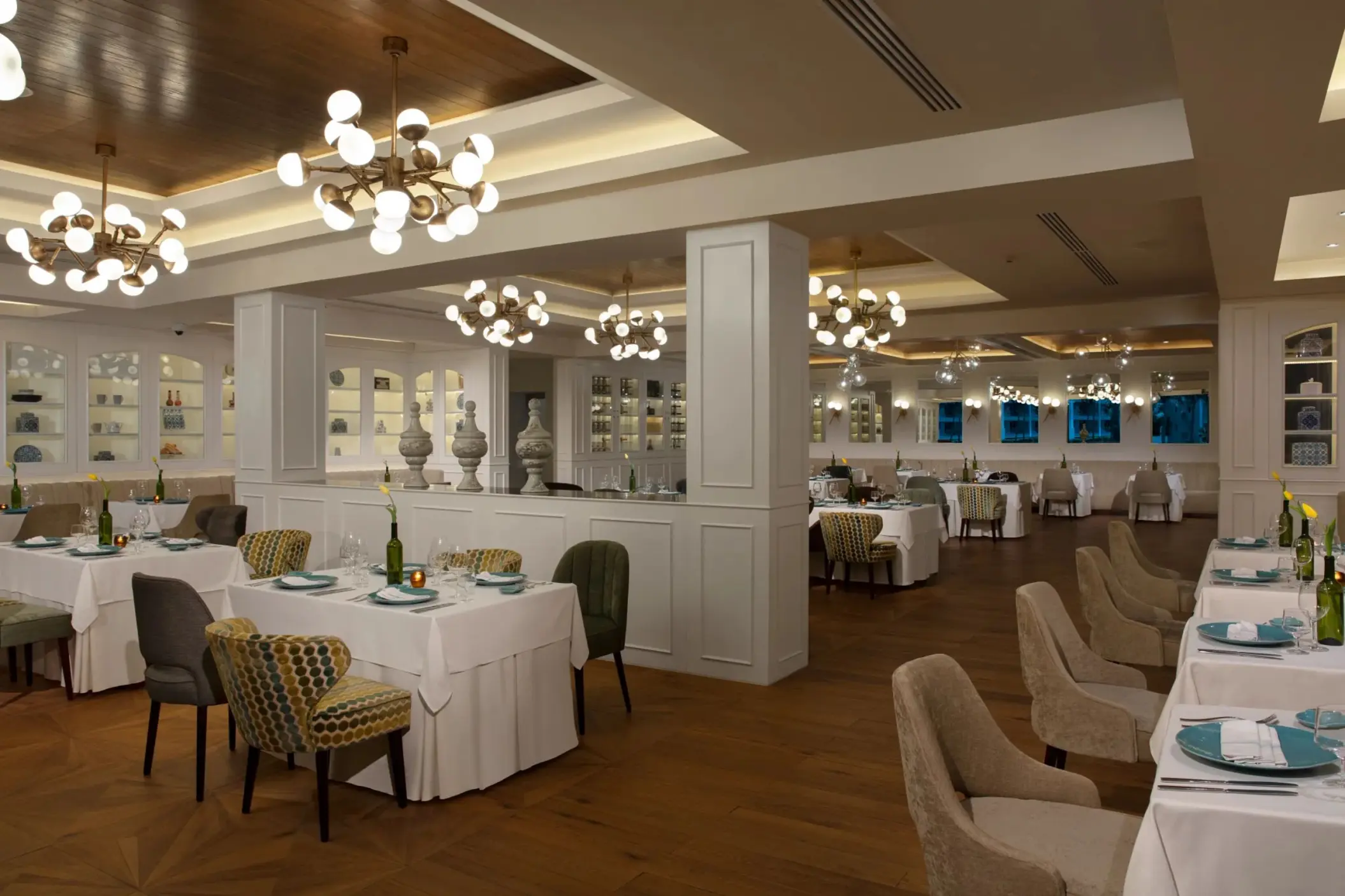 Bright, modern restaurant with white tablecloths, stylish lighting fixtures, and contemporary decor.