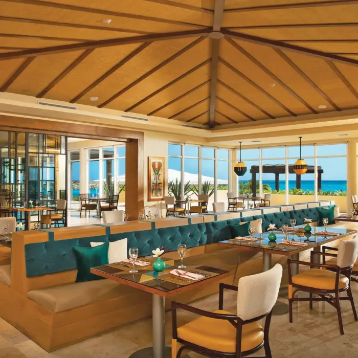 Spacious dining area at Carnival Café with vibrant décor, ocean views, and elegant table settings for casual meals.