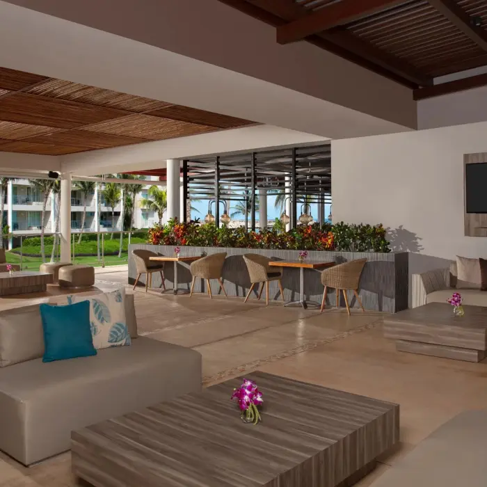 Relaxing outdoor café space with modern seating, flower arrangements, and garden views.