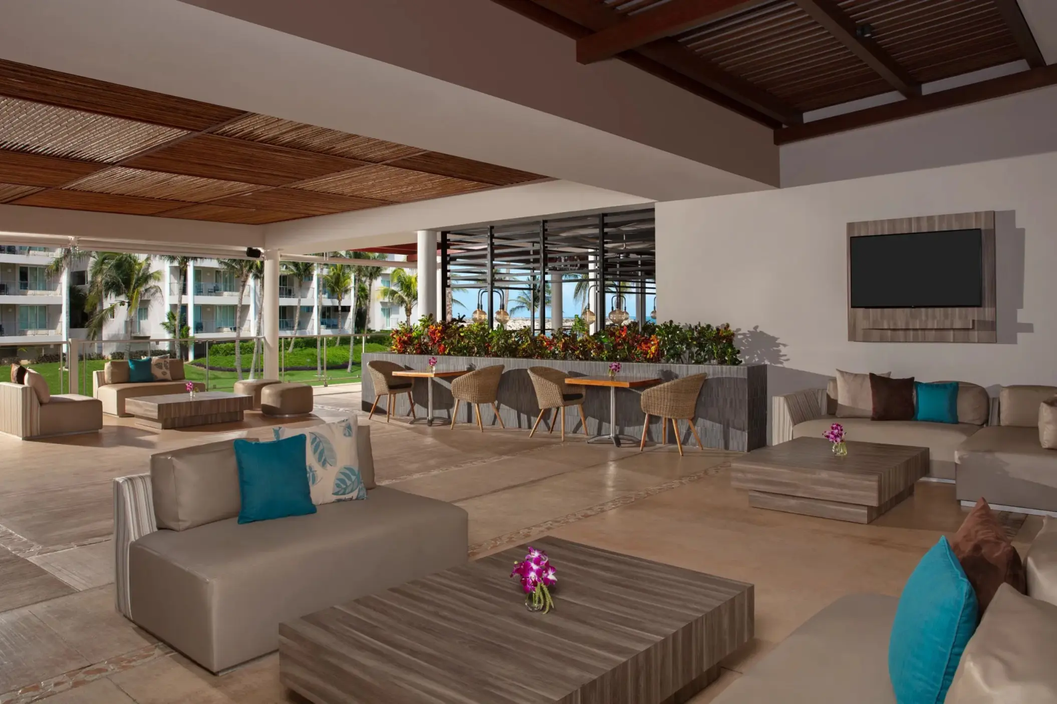 Relaxing outdoor café space with modern seating, flower arrangements, and garden views.