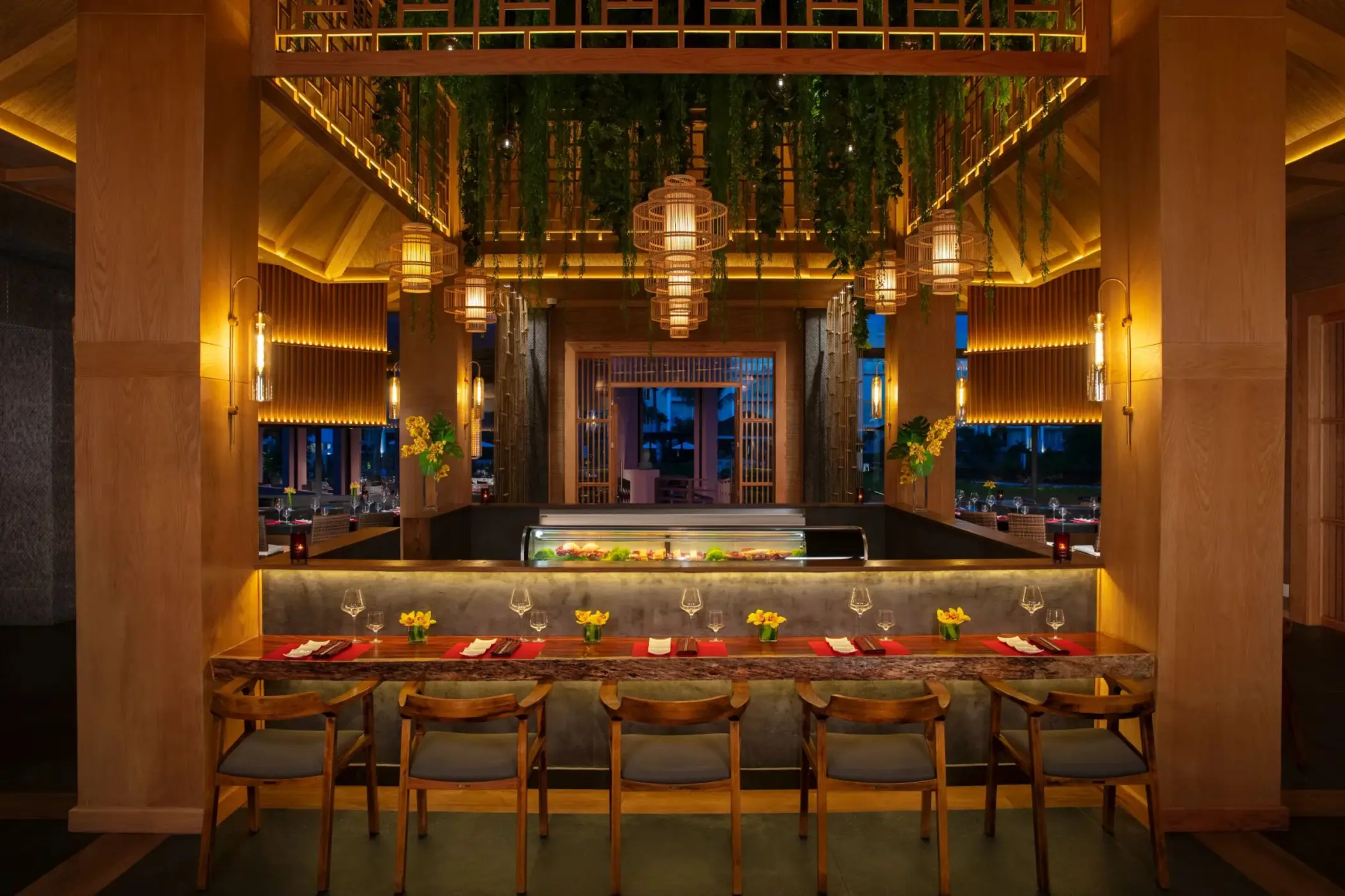 Warmly lit sushi bar with wood finishes, hanging lanterns, and a vibrant, inviting atmosphere.