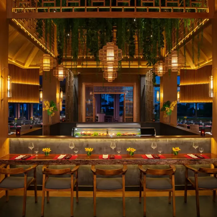 Warmly lit sushi bar with wood finishes, hanging lanterns, and a vibrant, inviting atmosphere.