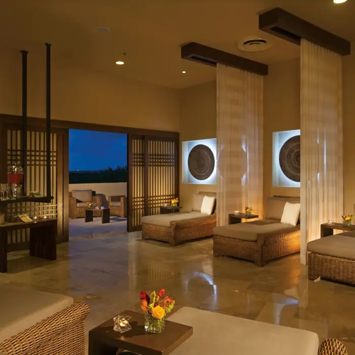 Serene spa relaxation lounge with wicker chairs, soft lighting, and open-air terrace for a peaceful retreat.