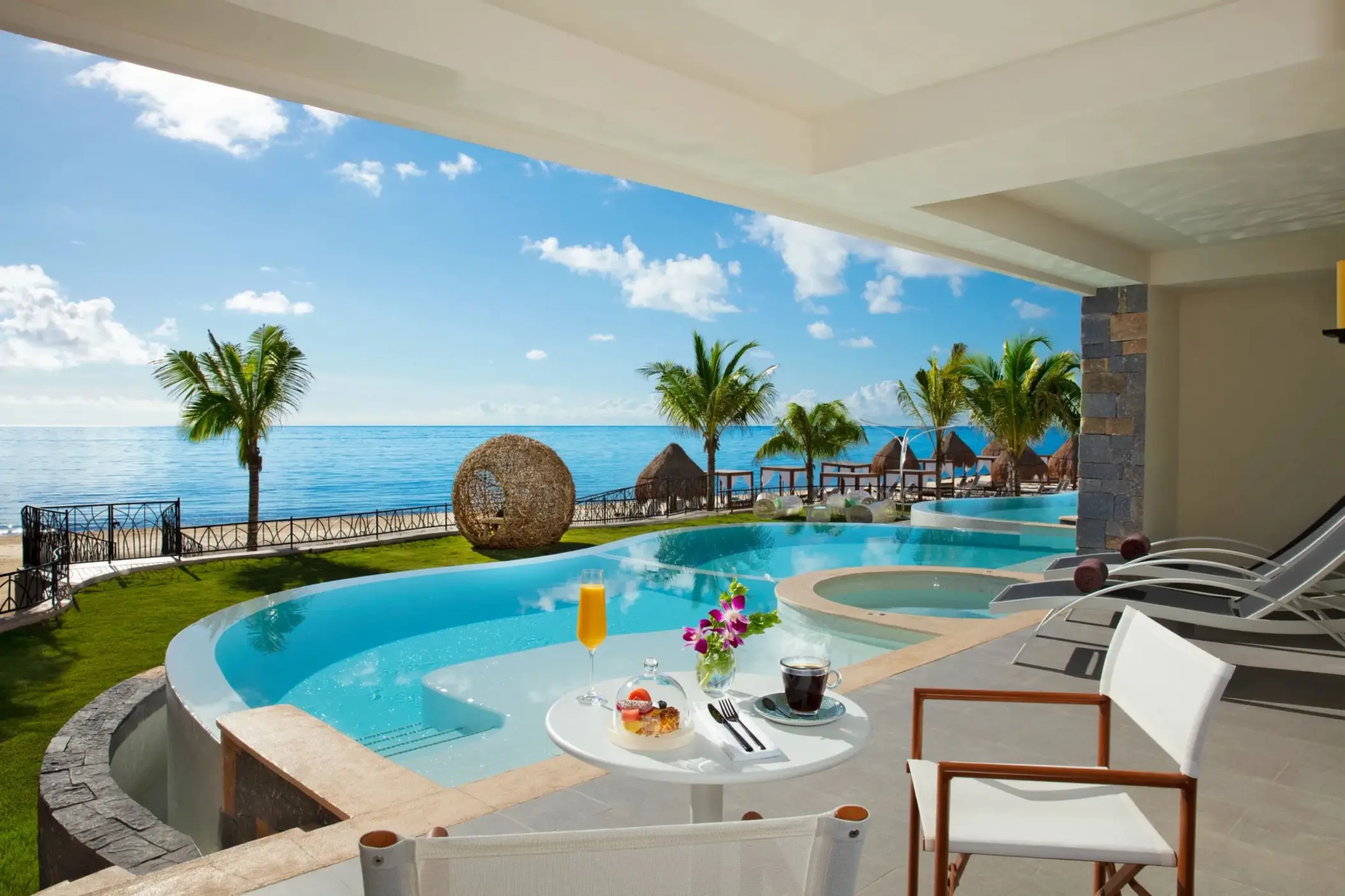 Private terrace with plunge pool, ocean views, and outdoor seating at an upscale beachfront suite.