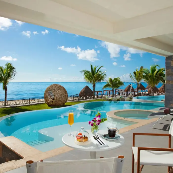 Private terrace with plunge pool, ocean views, and outdoor seating at an upscale beachfront suite.