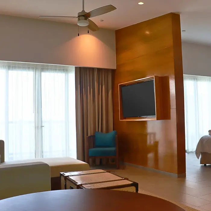 Spacious master suite with separate living and sleeping areas, wood divider wall, and floor-to-ceiling curtains.