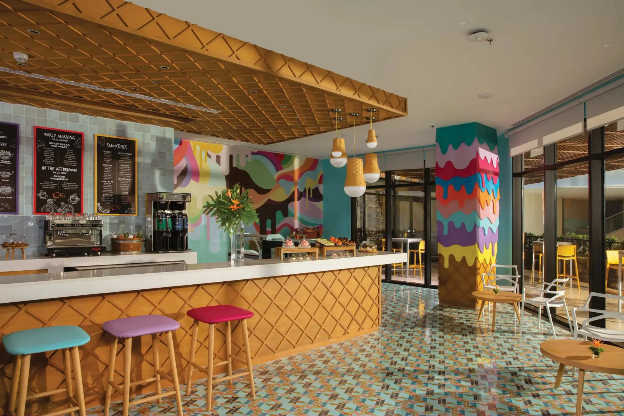 Bright café with waffle-cone inspired design, pastel seating, and artistic wall decor.