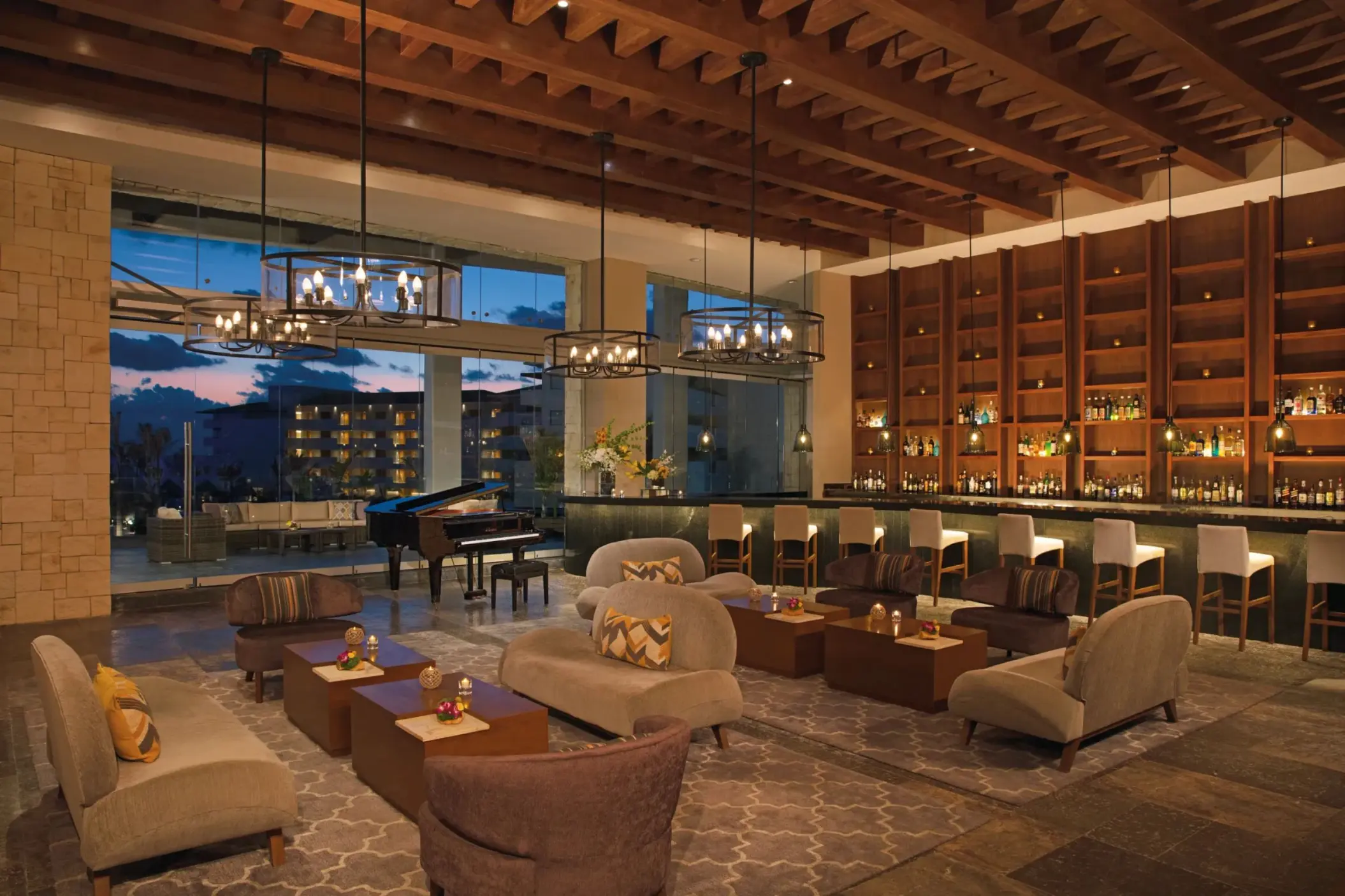 Interlude lobby bar with plush seating, piano, high ceilings, and wall-to-wall bar display.