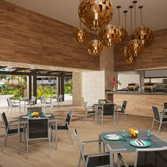 Tides Bar with casual outdoor dining area, wood accents, and hanging globe light fixtures.