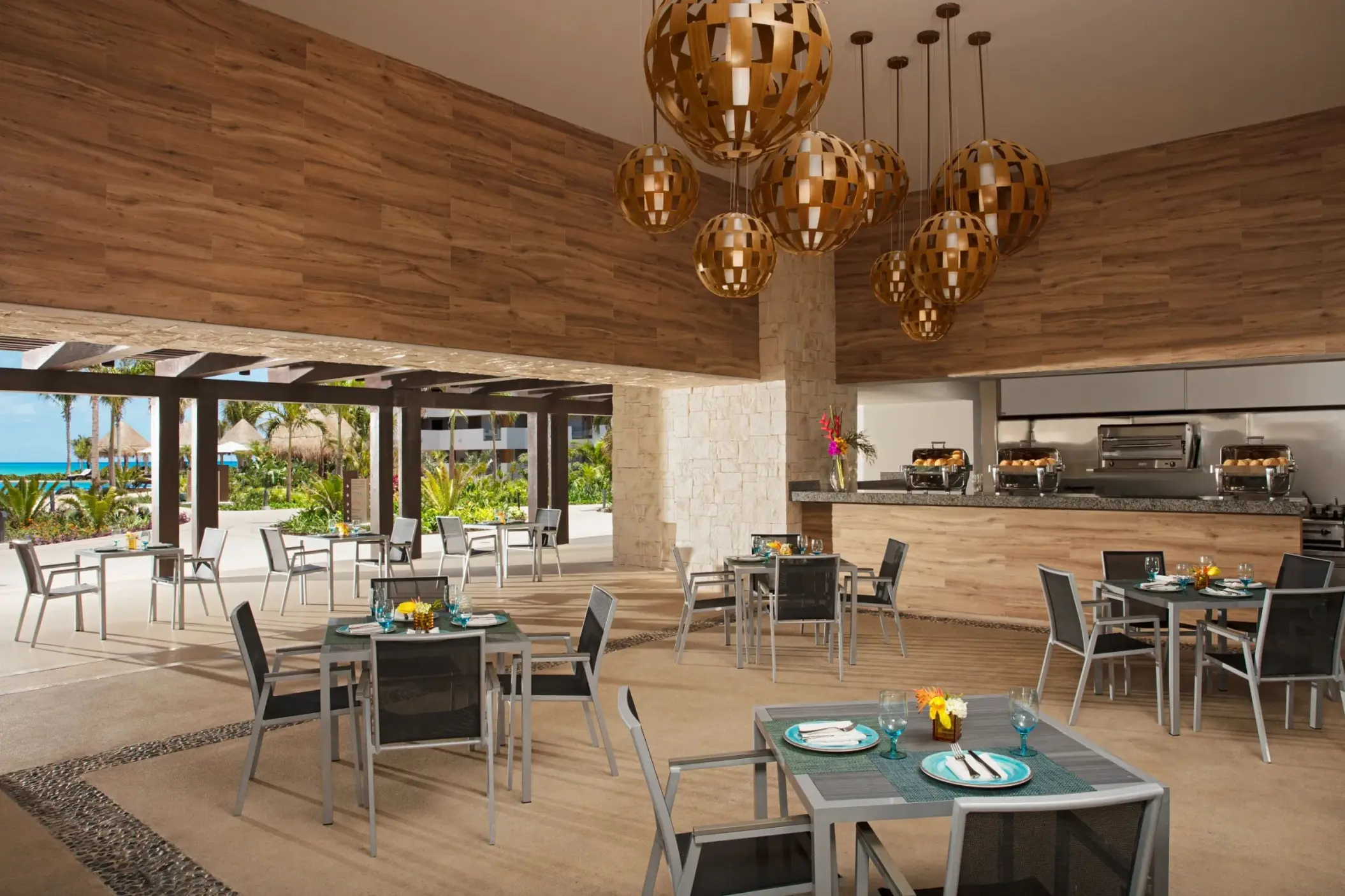 Tides Bar with casual outdoor dining area, wood accents, and hanging globe light fixtures.