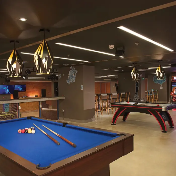 Core Zone teen club with pool table, air hockey, arcade games, and stylish modern lighting fixtures.